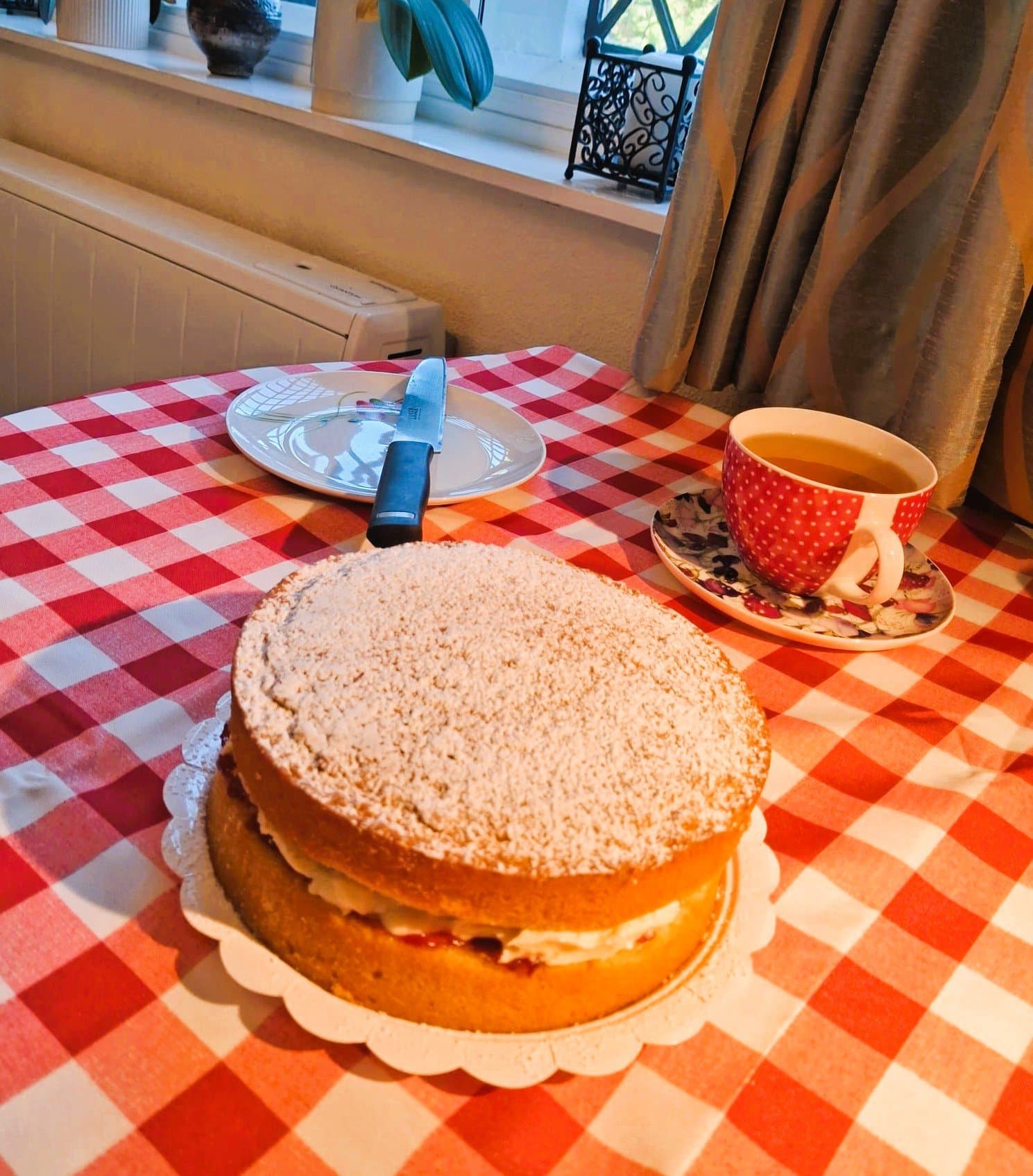 Dairy-free Victoria sponge filled with raspberry jam and buttercream, dusted with icing sugar, by Farmhouse Cakes